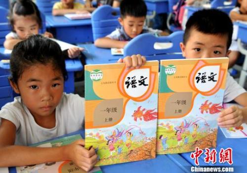 資料圖:一年級(jí)新生展示剛領(lǐng)取的語文統(tǒng)編教材 張斌 攝